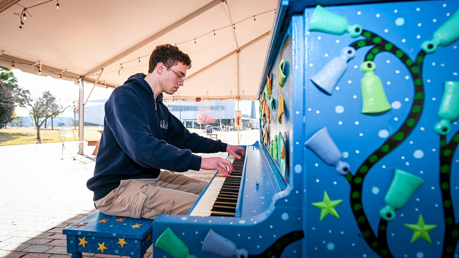 NC State student Andrew Farkas plays the piano on Centennial Campus